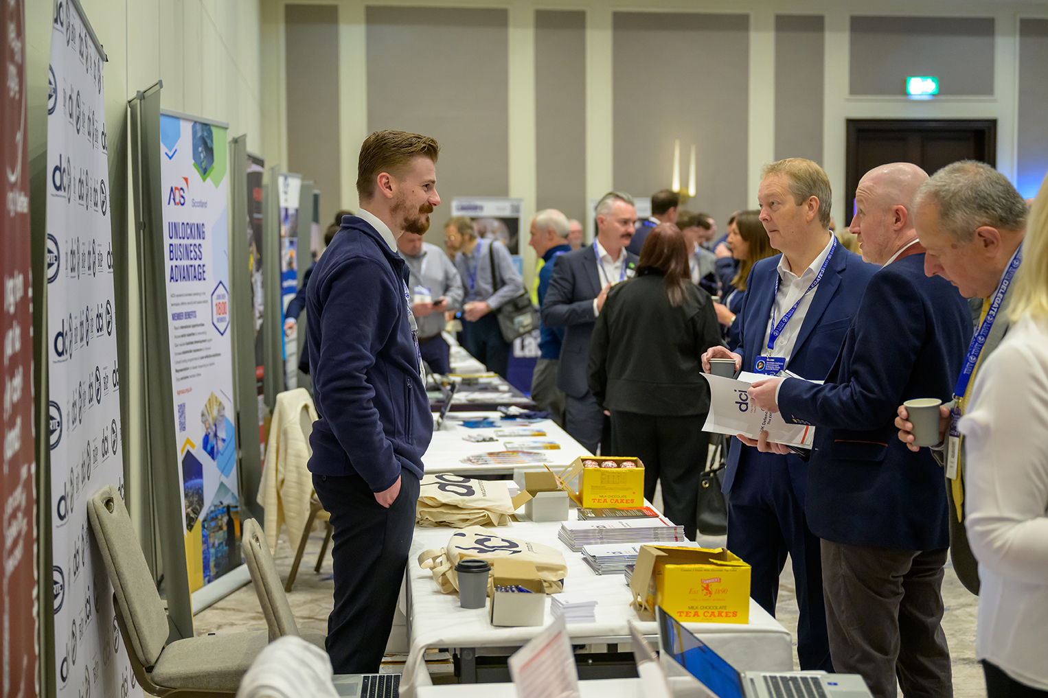 An exhibitor talking to two delegates at a dressed tabletop stand