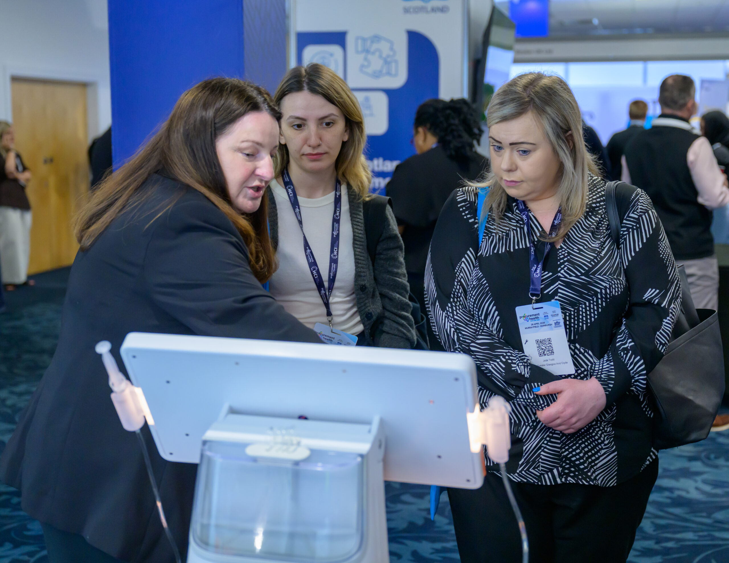 An exhibitor talking to two delegates across their tabletop display